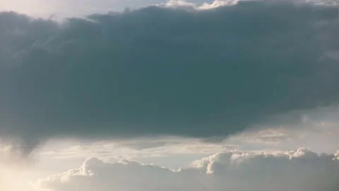 Clouds float across the sky and an airplane flies leaving a trail. Time laps. Stock Footage 142077579