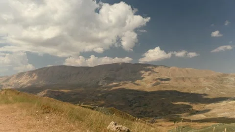 Clouds float across the sky and between green mountain views. Stock Footage 295875965