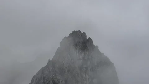 Clouds float over the rocky mountain peak Stock Footage 251997859