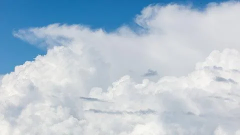 Clouds float peacefully under clear blue skies Stock Photos