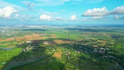 Clouds float in sky casting dark blob shadows on countryside of Karaikudi Stock Footage 263864956
