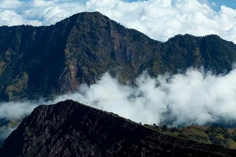 Clouds floating between the rocky mountains. Mount Rinjani, Lombok, Indonesia Stock Photos
