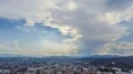 Clouds floating in blue sky over city with sunbeams penetrating them, timelapse 4k or 4k+ Resolution