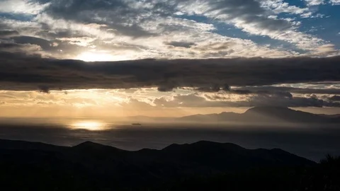 Clouds floating over mountains and sea during sunset Stock Footage 77548780