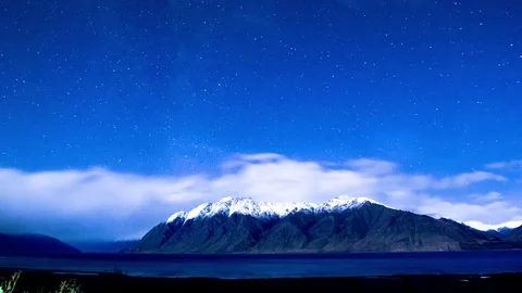 Clouds floating over snow covered mountains and Wanaka lake Stock Footage 76106113