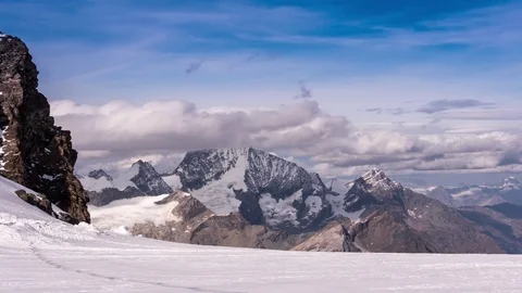 Clouds floating over snow covered mountains Stock Footage 77802802