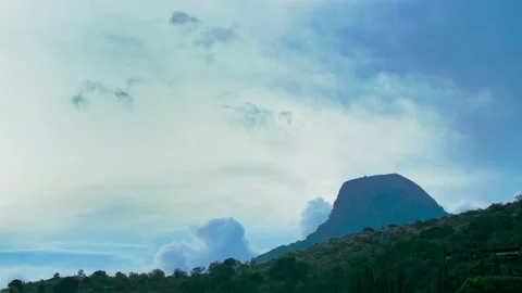 Clouds floating in the sky, terrain and a blunt-edged mountain. Coniferous Stock Footage 218403635