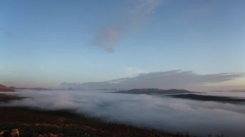 Clouds floating through a mountain valley Stock Footage 52395751