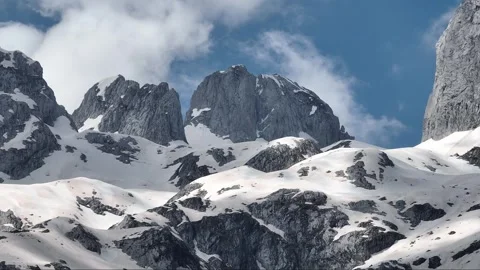 Clouds floats on blue sky over the mountain summit with a snow Stock Footage 251997980