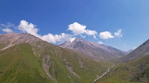 Clouds flow around the tops of high mountains. Stock Photos