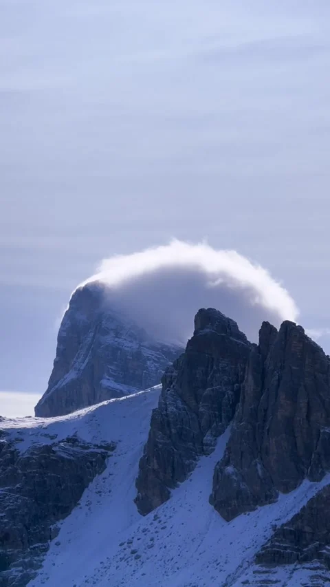 Clouds flowing around dramatic Dolomites mountain peak near Tre Cime. Stockbeeldmateriaal 330437442