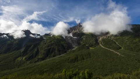 Clouds flowing over lush green mountain range 4K time lapse Stock Footage 107957151