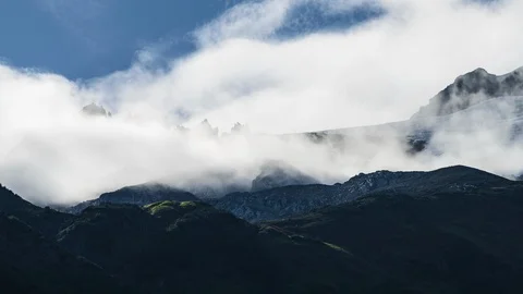 Clouds flowing over lush green mountains with waterfall 8K time lapse Stock Footage 114000385
