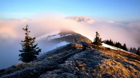 Clouds flowing over a mountain ridge and a mountain peak in a national park in Stock Footage 294594748