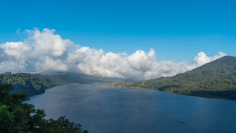Clouds fly across a clear sky near a lake and forest, a clear day, timelapse Stock Footage 102055568