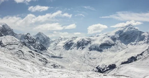 Clouds fly over mountain peaks covered with snow Stock Footage 79583276