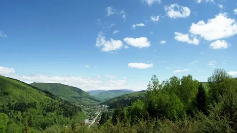 The clouds fly over the mountains and cast a shadow over the mountain village Video stock 75941272