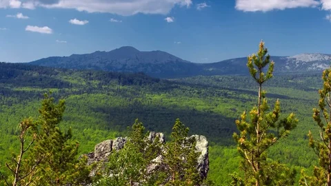 Clouds fly over the sunny mountain valley covered with spring forest TL 4K Stock Footage 82412705