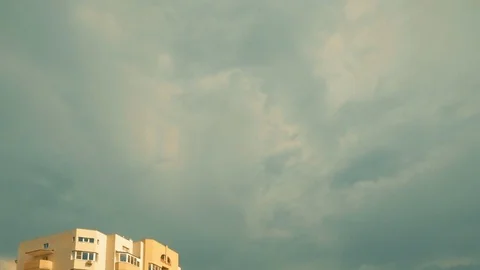 Clouds fly over top pf apartment building Stock Footage