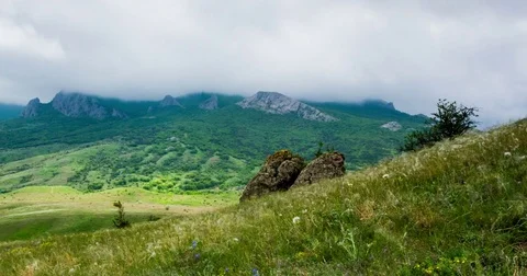 Clouds fly over the valley and mountain peaks Stock Footage 76425040