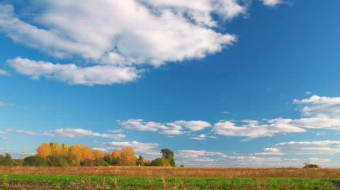 Clouds flying on blue sky over autumn forest and field Stock Footage