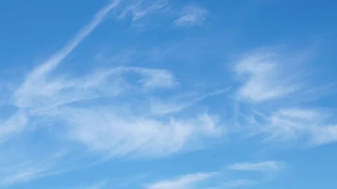 Clouds flying in a deep blue sky with mountains in background Stock Footage 76950772