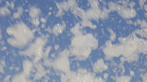 Clouds of foam fly against the blue sky Stock Footage 284714158