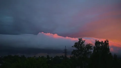 Clouds form and shift during sunset, displaying vibrant colors against a 動画素材 344440981
