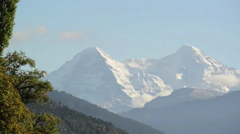 Clouds form around a snow covered mountain Stock Footage 32281257