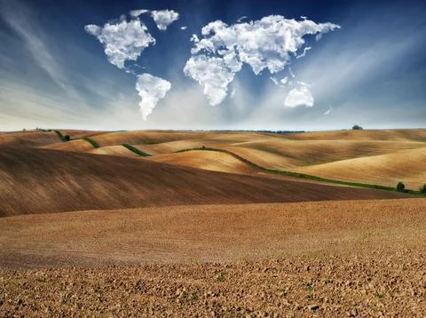 Clouds in the form of a map of the world over the field Stock Photos