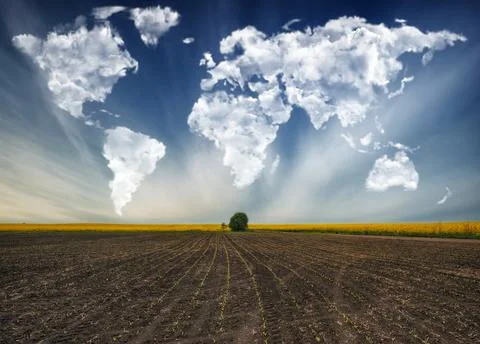 Clouds in the form of a map of the world over the field Stock Photos