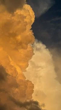 Clouds form in a sky at sunset with shades of orange and white near a horiz.. Stock Photos