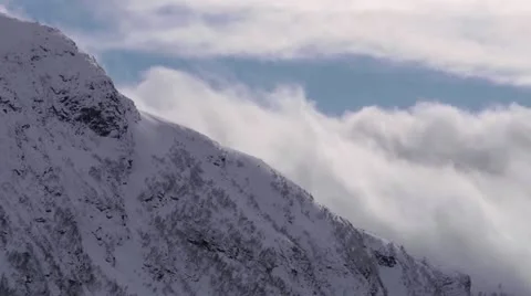 Clouds forming behind snow covered mountain. time lapse Stock Footage
