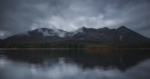 Clouds forming over mountains with reflection in lake Stock Footage 132299902