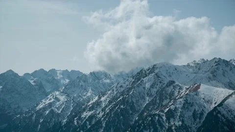 Clouds forming over rocky and snowy mountains 스톡 동영상 230009458
