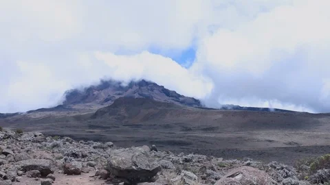 Clouds free flowing over a barren mountain in Kilimanjaro Stock Footage 106351360