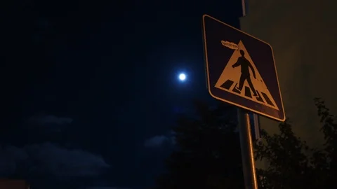 Clouds in front of the moon, against the background of a road sign, Stock Footage 117974687