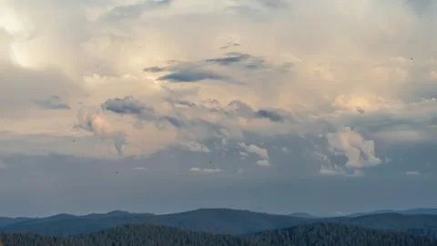 Clouds gather in the evening sky, displaying shades of blue and gray over a Stock Photos