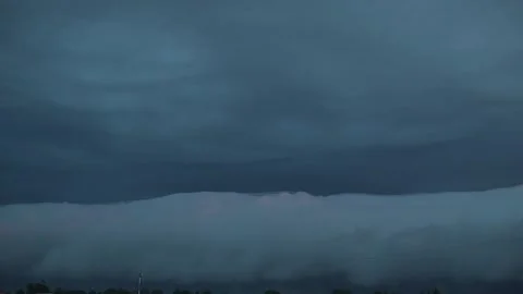Clouds gather in a thick formation over a flat landscape as a storm approaches Video stock 344440941