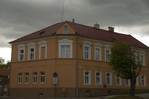 Clouds gathering above charming yellow building with detailed window frames Fotos Stock
