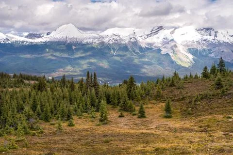 Clouds gathering above the mountain range in Canadian Rockies. Maligne lake in Stock Photos