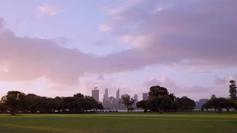 Clouds glide above tree-lined park - background features Perth City and river Stock Footage 158962637