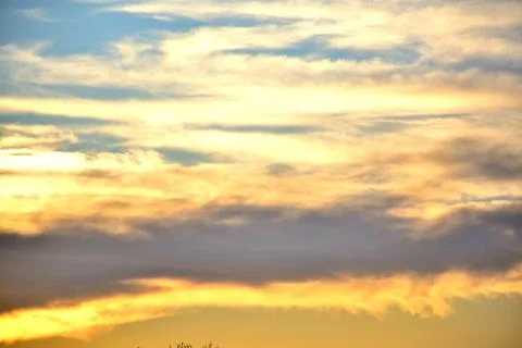 Clouds glow from the setting sun.	 Stock Photos