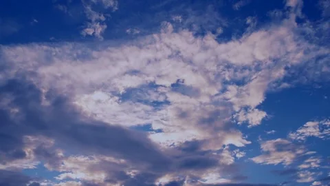 Clouds going into the red colour with black patterns float over the blue sky Stock Footage 137932612