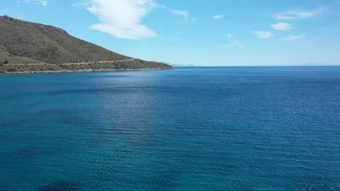 Clouds gracefully forming above the serene coastline of a greek island Vídeos de archivo 301873015