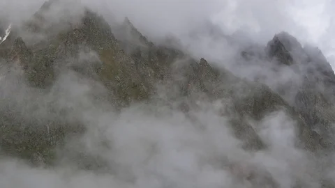 Clouds growing under sharp rock Stock Footage 77248652