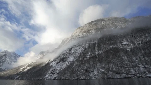 Clouds hang low in Bavarian alps leading down to cold mountain lake Stock Footage 120988153