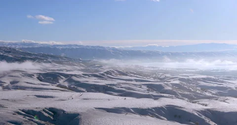 Clouds hang over snow-covered mountain ranges Vidéo 151975306