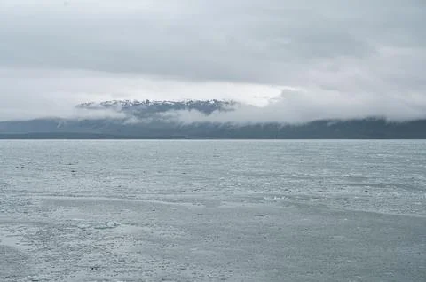 Clouds hanging in layers on the snow capped mountains of South East Alaska, USA Stock Photos