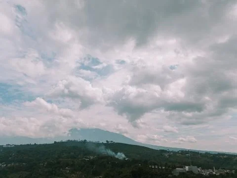 Clouds hovering over a mountain in a village with an overcast sky, Foto stock